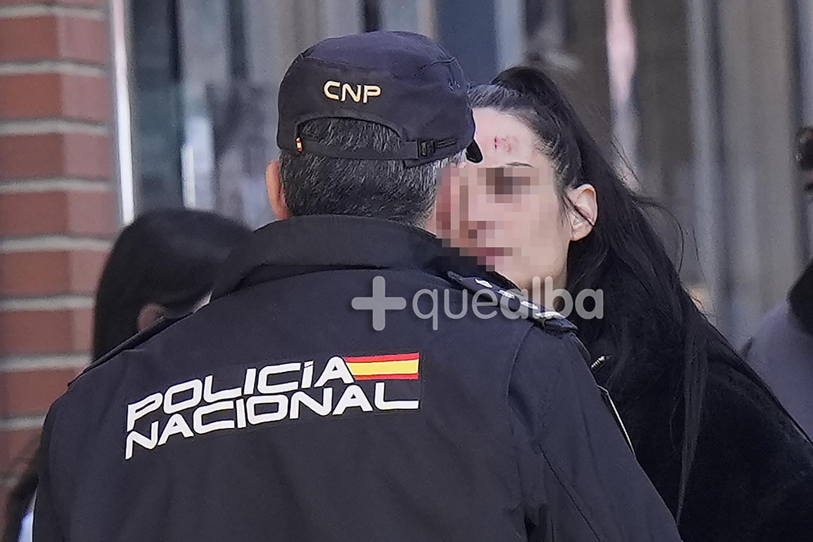 La herida en la frente de la pareja del detenido era visible. La mujer conversa con un Policía en el lugar del suceso.